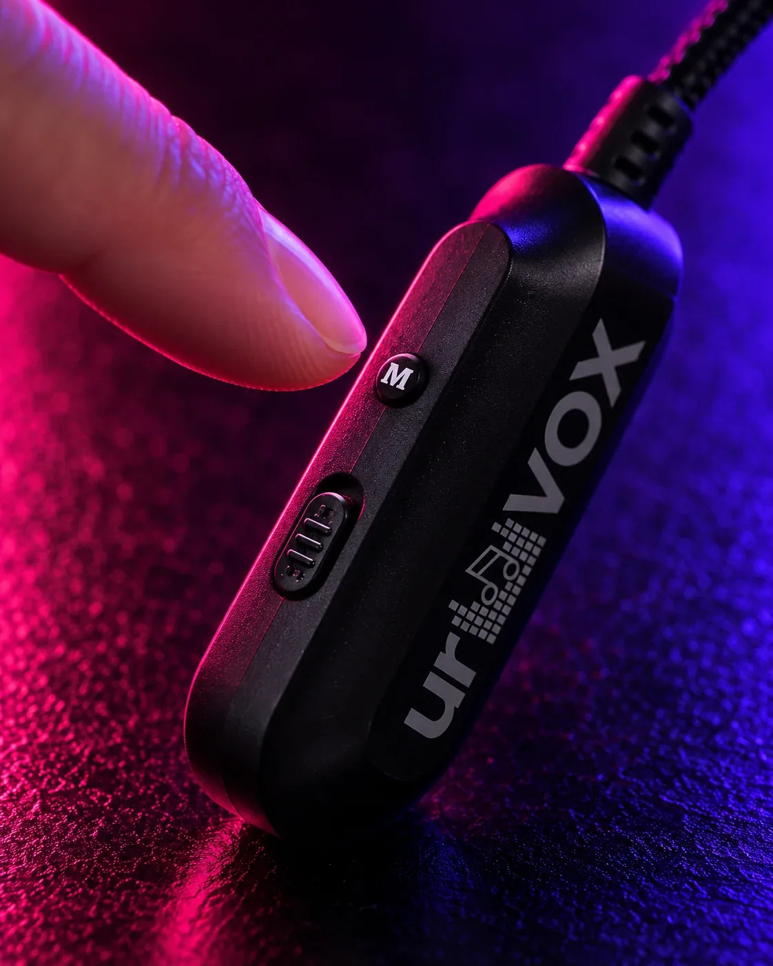 A fingertip about to press the M button on the side of urVOX, next to the ON/OFF switch